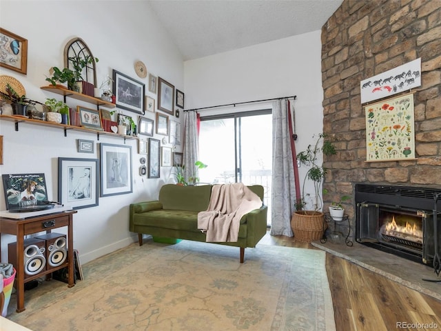 living room with lofted ceiling, hardwood / wood-style floors, and a fireplace