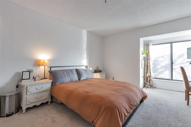 bedroom with light carpet and a textured ceiling