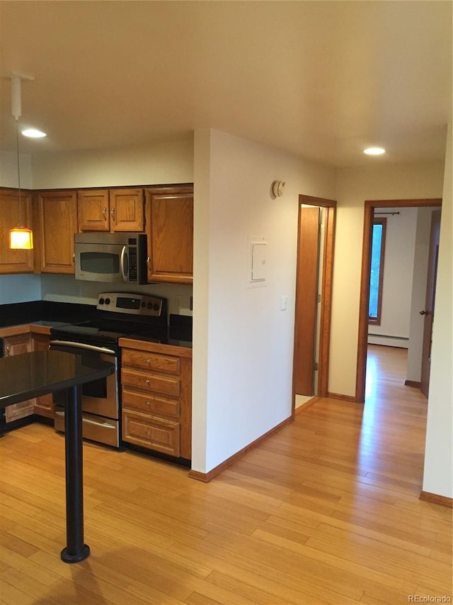 31270 John Wallace Rd Unit 310, Evergreen, CO 80439 - kitchen with stainless steel appliances, baseboard heating, dark countertops, light wood finished floors, and recessed lighting