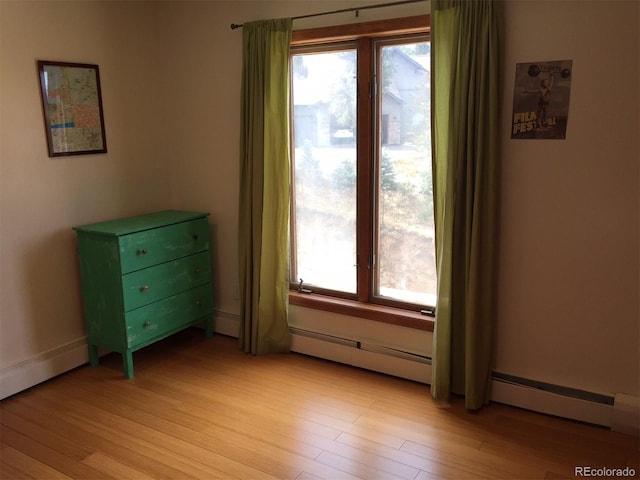 31270 John Wallace Rd Unit 310, Evergreen, CO 80439 - bedroom featuring multiple windows, light wood finished floors, and a baseboard radiator