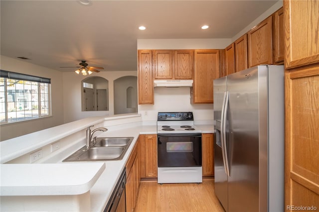 kitchen featuring appliances with stainless steel finishes, sink, kitchen peninsula, ceiling fan, and light hardwood / wood-style floors