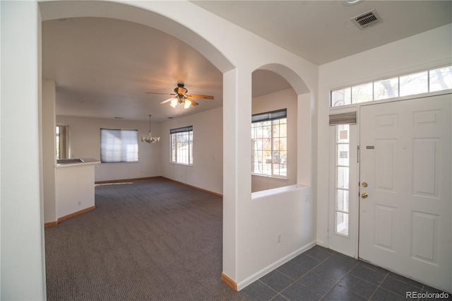 carpeted entrance foyer featuring ceiling fan with notable chandelier