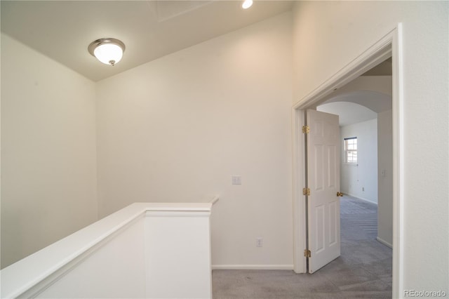 corridor featuring light carpet and lofted ceiling