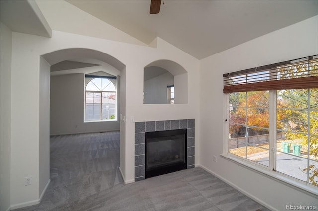 unfurnished living room featuring lofted ceiling, carpet flooring, and a wealth of natural light