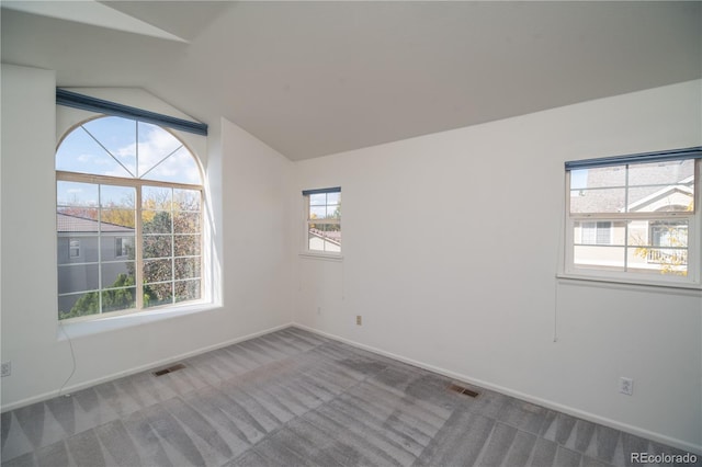 unfurnished room with lofted ceiling and carpet flooring