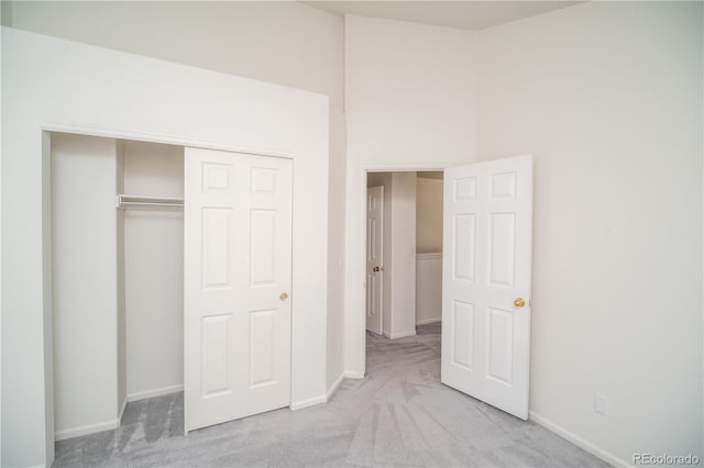 unfurnished bedroom with a closet and light colored carpet