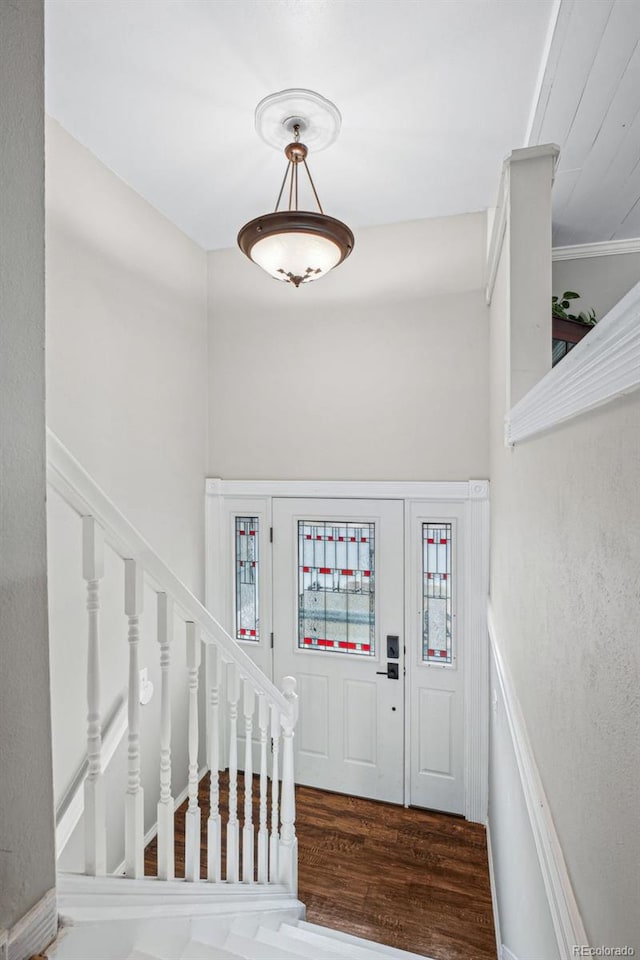 entrance foyer with dark hardwood / wood-style flooring and ornamental molding