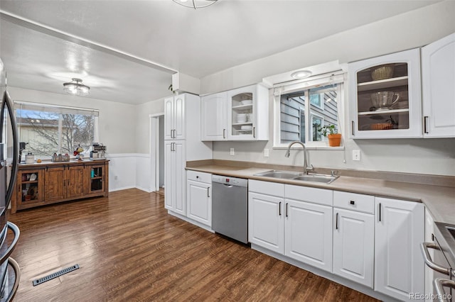 7636 S Eaton Way, Littleton, CO 80128 - kitchen featuring stainless steel dishwasher, a wainscoted wall, stove, glass insert cabinets, and white cabinetry