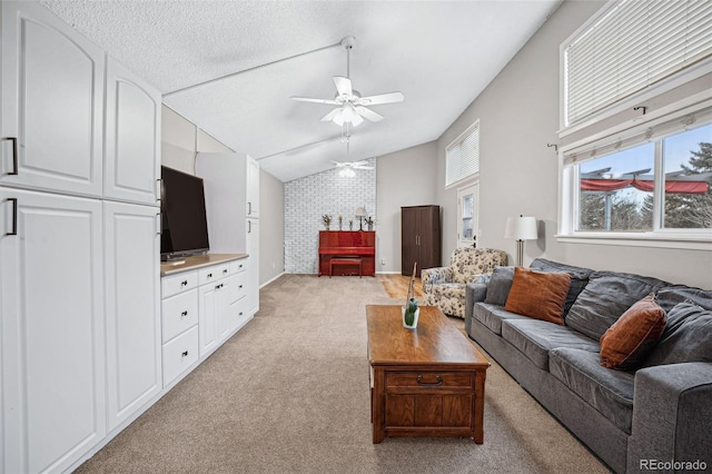 carpeted living room with a textured ceiling, vaulted ceiling, and ceiling fan