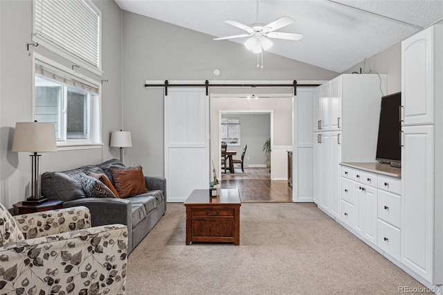 7636 S Eaton Way, Littleton, CO 80128 - living area with a barn door, a ceiling fan, light carpet, and high vaulted ceiling