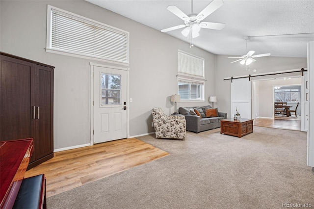 7636 S Eaton Way, Littleton, CO 80128 - living area featuring a barn door, ceiling fan, healthy amount of natural light, and vaulted ceiling