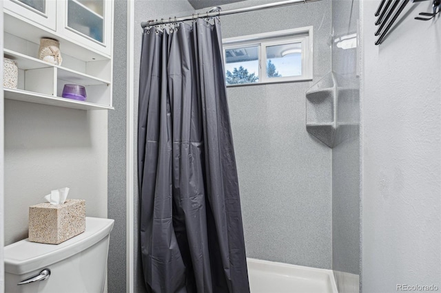 bathroom with a shower with curtain and toilet