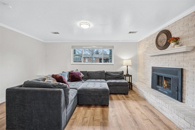 7636 S Eaton Way, Littleton, CO 80128 - living room featuring light wood-type flooring, crown molding, and a fireplace