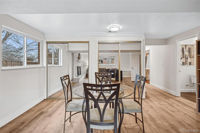 7636 S Eaton Way, Littleton, CO 80128 - dining space with light wood-style flooring and a fireplace