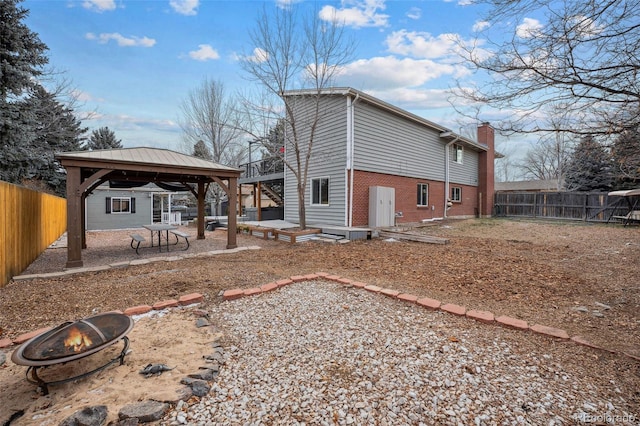 7636 S Eaton Way, Littleton, CO 80128 - rear view of property with a gazebo, a fire pit, brick siding, a chimney, and a patio