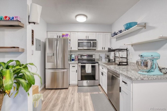 5300 E Cherry Creek S Drive 804, Denver, CO 80246 - kitchen featuring open shelves, appliances with stainless steel finishes, white cabinetry, and light wood-style flooring