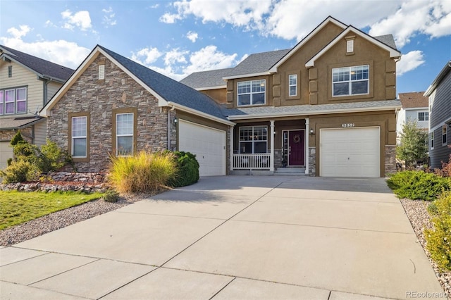 view of front of house with a garage, concrete driveway, stone siding, and stucco siding