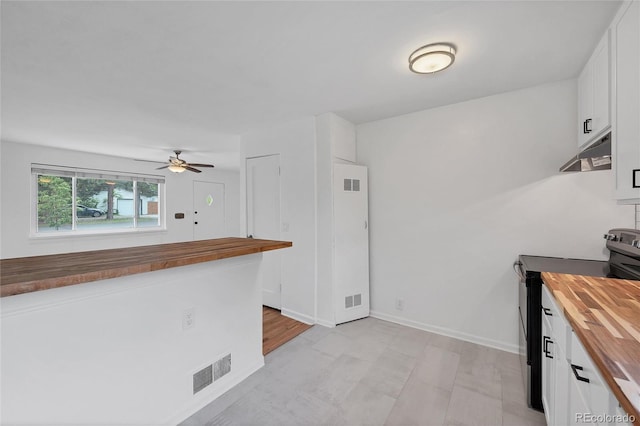 6765 W 33rd Ave, Wheat Ridge, CO 80033 - kitchen featuring butcher block counters, stainless steel range with electric stovetop, under cabinet range hood, white cabinets, and a ceiling fan