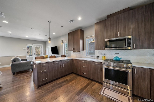 kitchen featuring visible vents, dark wood-type flooring, open floor plan, light countertops, and appliances with stainless steel finishes