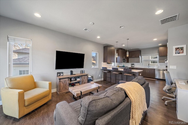 living room featuring recessed lighting, dark wood-style floors, and visible vents