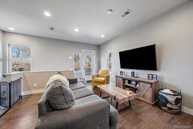 living room featuring baseboards, visible vents, and dark wood-style flooring