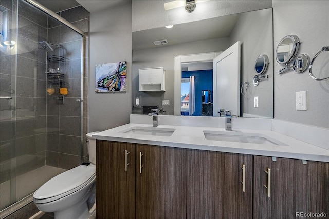 bathroom featuring a shower stall, toilet, visible vents, and a sink