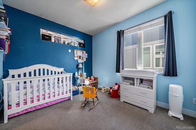 bedroom featuring carpet flooring, a crib, and baseboards