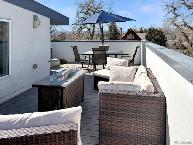 wooden terrace with an outdoor living space with a fire pit