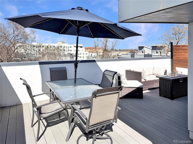 wooden deck with an outdoor living space with a fire pit and outdoor dining space