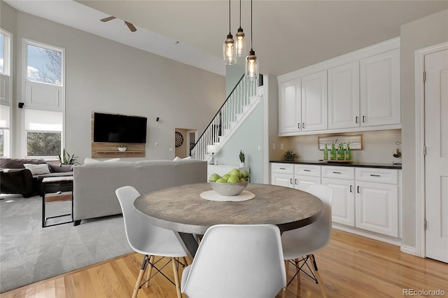 7472 S Utica St, Littleton, CO 80128 - dining room featuring light wood-style flooring, stairway, and a ceiling fan