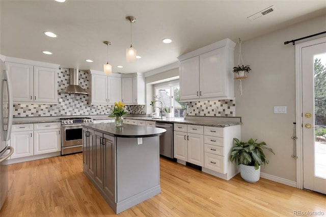 7472 S Utica St, Littleton, CO 80128 - kitchen featuring stainless steel appliances, wall chimney exhaust hood, white cabinetry, decorative backsplash, and recessed lighting