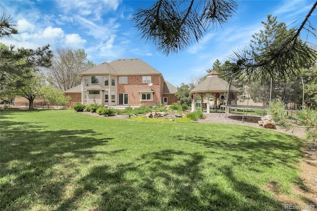 7472 S Utica St, Littleton, CO 80128 - back of property featuring a gazebo, a trampoline, a lawn, and brick siding