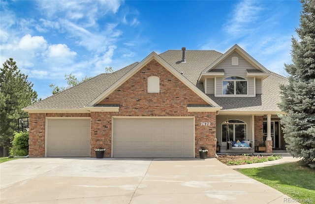 7472 S Utica St, Littleton, CO 80128 - traditional home featuring driveway, an attached garage, brick siding, roof with shingles, and a porch