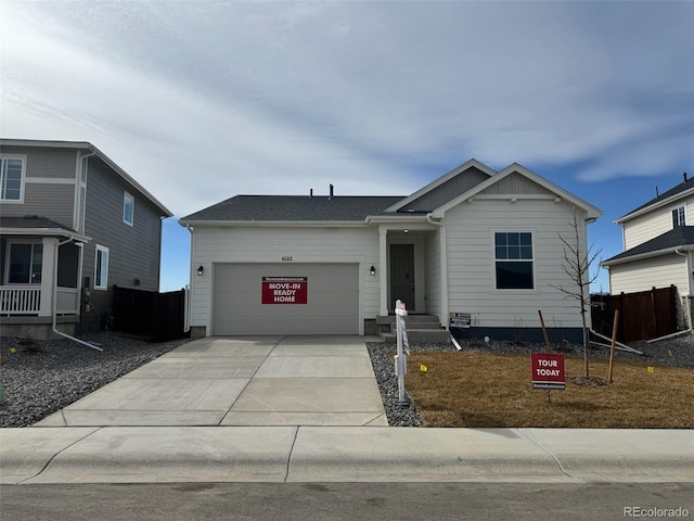 view of front of property featuring concrete driveway, a garage, fence, and board and batten siding