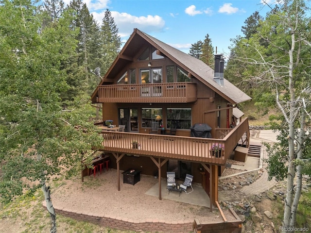 32462 Lodgepole Dr, Evergreen, CO 80439 - back of house with a patio, a wooden deck, a chimney, and a balcony