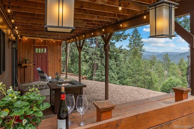 32462 Lodgepole Dr, Evergreen, CO 80439 - wooden terrace featuring an outdoor fire pit, a mountain view, and a view of trees