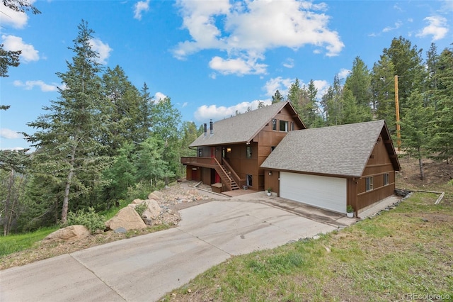 32462 Lodgepole Dr, Evergreen, CO 80439 - chalet / cabin with a shingled roof, driveway, stairway, and a garage