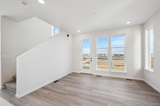 unfurnished room with plenty of natural light and light hardwood / wood-style floors