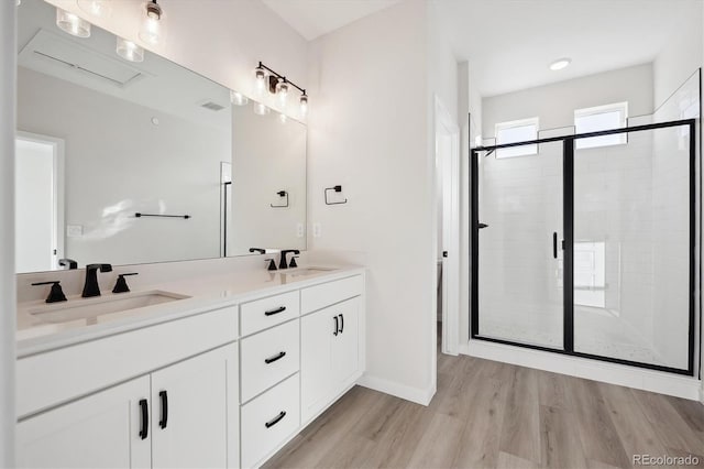 bathroom featuring vanity, wood-type flooring, and walk in shower