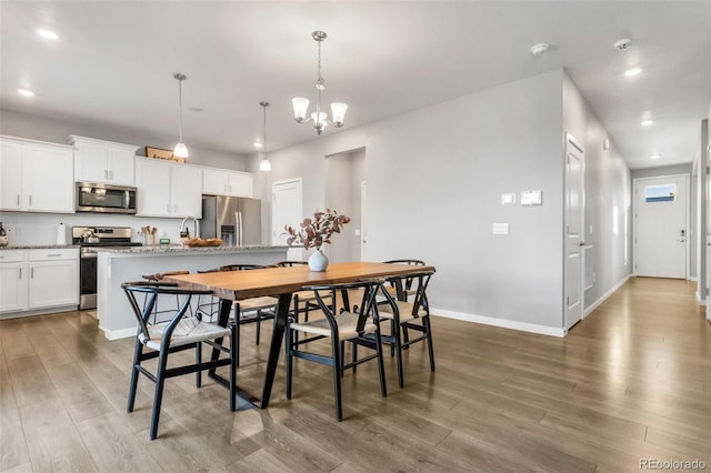 dining area featuring recessed lighting, baseboards, an inviting chandelier, and wood finished floors