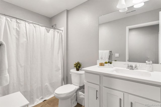 bathroom featuring toilet, a shower with curtain, visible vents, and vanity