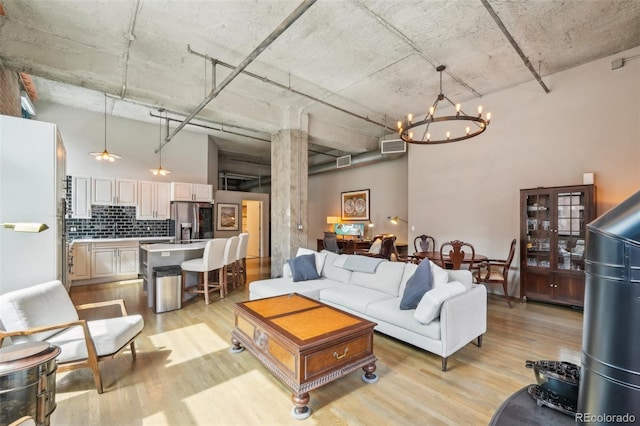 1801 Wynkoop St Unit 208, Denver, CO 80202 - living room featuring light wood-type flooring, a chandelier, and a towering ceiling