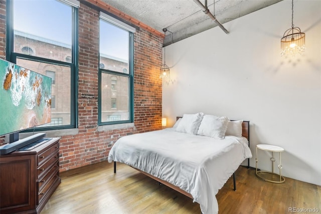 1801 Wynkoop St Unit 208, Denver, CO 80202 - bedroom with wood finished floors, brick wall, and a high ceiling