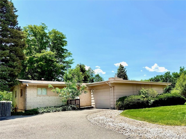 6040 W Elmhurst Dr, Littleton, CO 80128 - view of front facade featuring asphalt driveway, an attached garage, and brick siding
