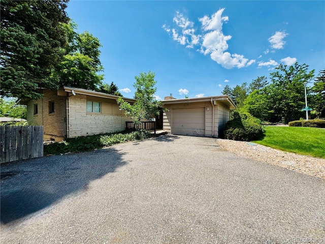 6040 W Elmhurst Dr, Littleton, CO 80128 - view of front of home featuring driveway, a garage, and stone siding