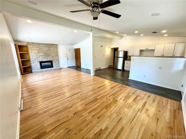 6040 W Elmhurst Dr, Littleton, CO 80128 - unfurnished living room with vaulted ceiling, a ceiling fan, wood finished floors, a fireplace, and recessed lighting