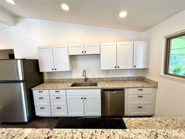 6040 W Elmhurst Dr, Littleton, CO 80128 - kitchen with stainless steel appliances, lofted ceiling, white cabinetry, light stone countertops, and recessed lighting