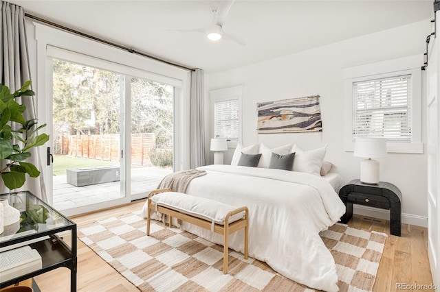 bedroom featuring multiple windows, ceiling fan, access to exterior, and light wood-type flooring