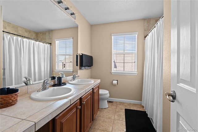 16896 E Maplewood Dr, Aurora, CO 80016 - full bathroom featuring double vanity, healthy amount of natural light, tile patterned floors, and a shower with curtain