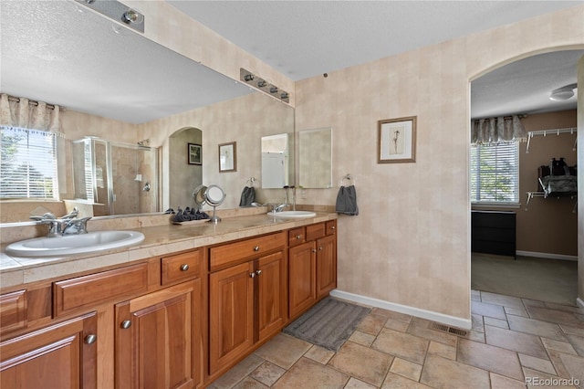 16896 E Maplewood Dr, Aurora, CO 80016 - full bathroom with a shower stall, double vanity, stone tile flooring, and a textured ceiling